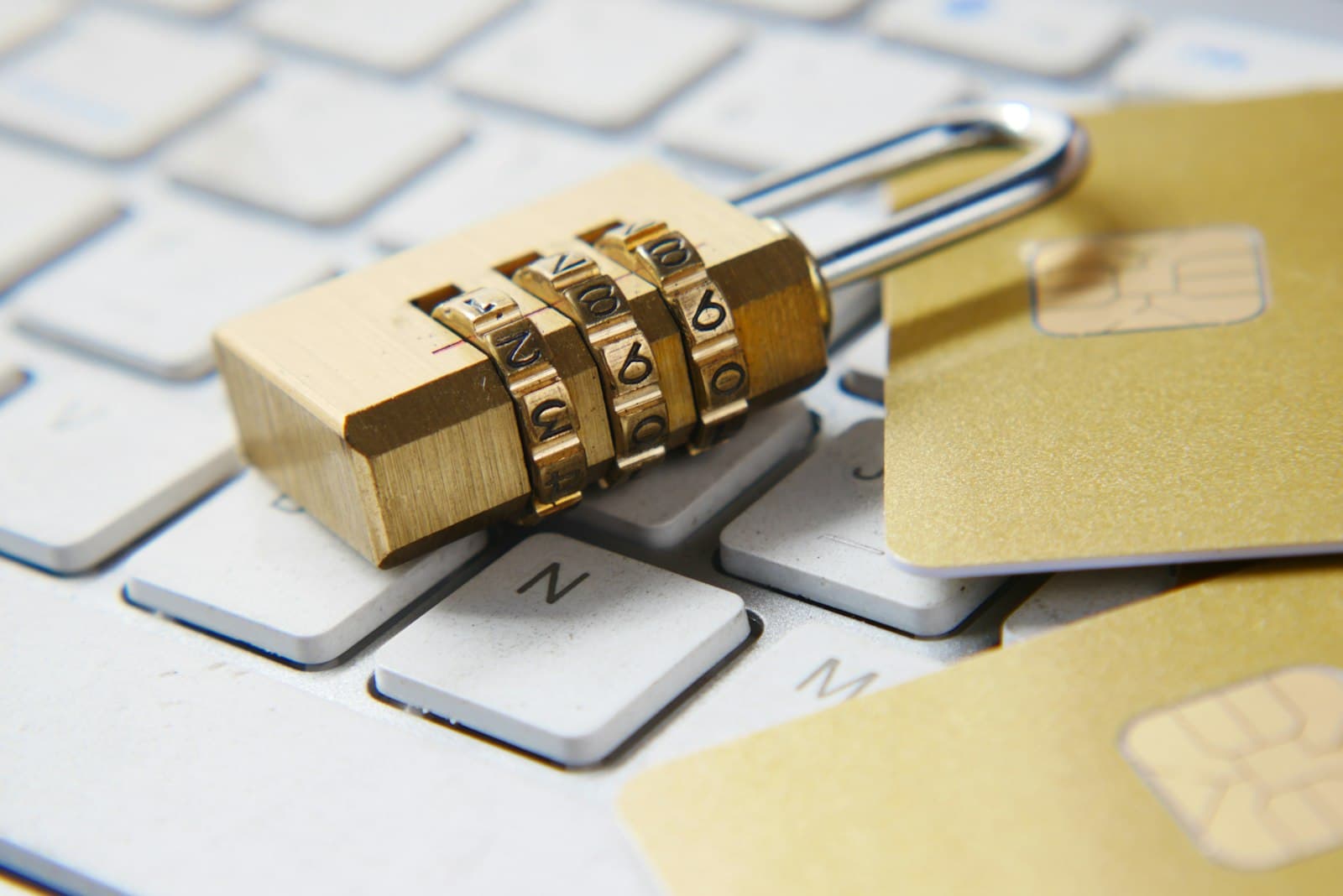 Gold padlock resting on top of a black computer keyboard